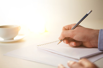 Image showing The male hands with a pencil and the cup