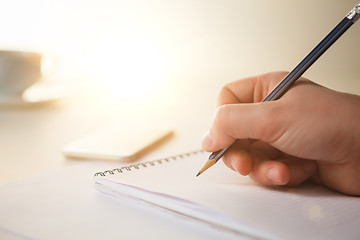 Image showing The male hand with a pencil and the cup