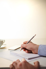 Image showing The male hands with a pencil and the cup