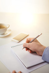 Image showing The male hands with a pencil and the cup