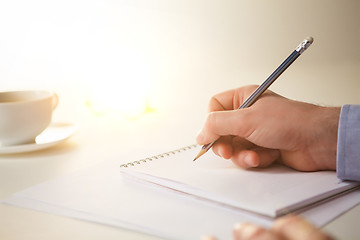 Image showing The male hand with a pencil and the cup