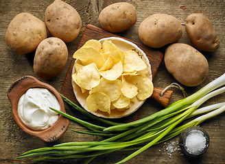 Image showing Potato chips on wooden table