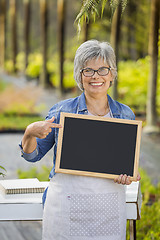 Image showing Elderly woman in a green house