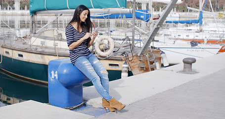 Image showing Trendy young woman relaxing at a marine harbour