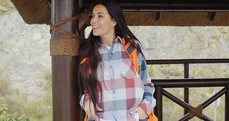 Image showing Young female hiker relaxing at a mountain lookout