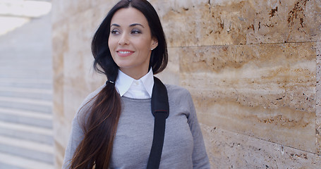 Image showing Confident young woman leaning against wall