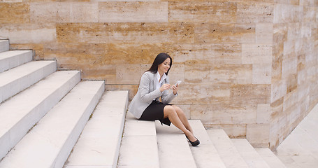 Image showing Pretty business woman sitting on steps using phone