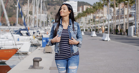 Image showing Trendy jaunty young woman enjoying a stroll