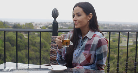 Image showing Young woman enjoying a hot cup of tea