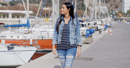 Image showing Pretty woman strolling on a waterfront promenade