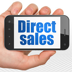 Image showing Marketing concept: Hand Holding Smartphone with Direct Sales on display