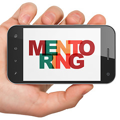 Image showing Learning concept: Hand Holding Smartphone with Mentoring on  display