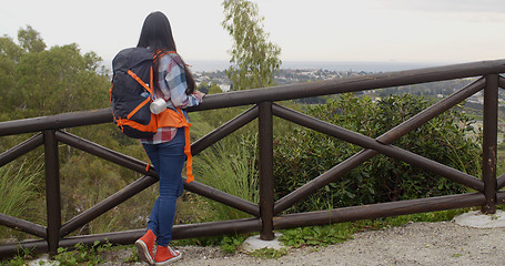 Image showing Young woman with a backpack admiring the scenery