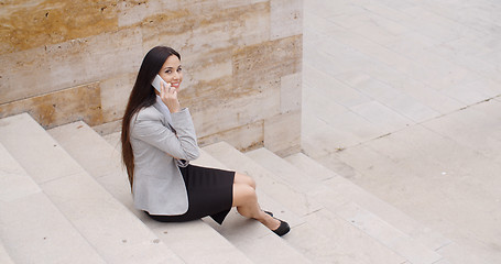 Image showing Cute business woman sitting on steps with phone