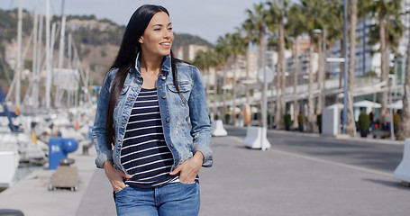 Image showing Casual woman enjoying a walk through a marina