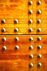 Image showing metal  paint in the     red wood door and rusty  yellow  