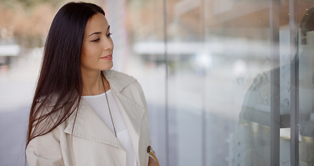 Image showing Young woman eyeing an item for sale