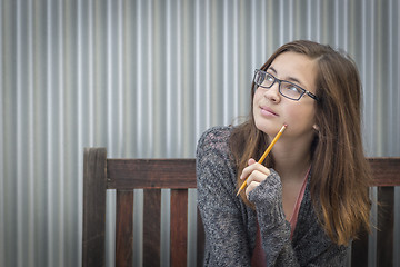 Image showing Young Daydreaming Female Student With Pencil Looking to the Side