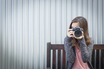 Image showing Girl Photographer Sitting and Pointing Camera