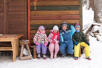 Image showing little children group sitting  together  in front of wooden cabi