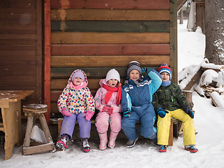 Image showing little children group sitting  together  in front of wooden cabi