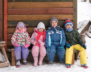 Image showing little children group sitting  together  in front of wooden cabi