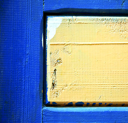 Image showing dirty stripped paint in the blue wood door and rusty nail