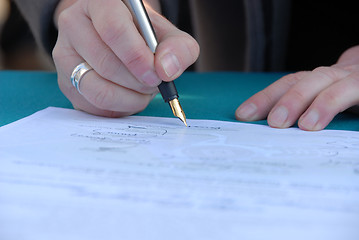 Image showing Businessman is signing a contract