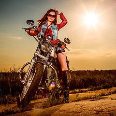 Image showing Biker girl sitting on motorcycle