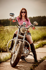 Image showing Biker girl sitting on motorcycle