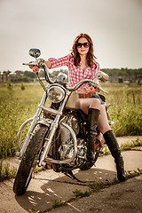 Image showing Biker girl sitting on motorcycle