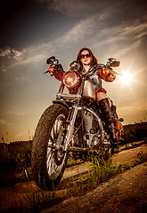 Image showing Biker girl sitting on motorcycle