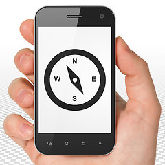 Image showing Vacation concept: Hand Holding Smartphone with Compass on display