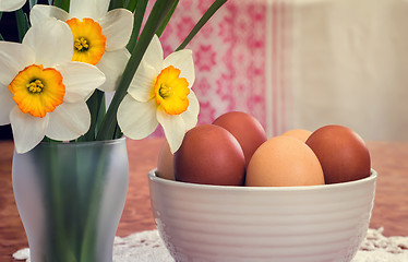 Image showing Easter eggs in a ceramic vase and flowers daffodils.