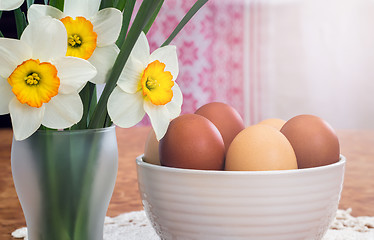 Image showing Easter eggs in a ceramic vase and flowers daffodils.
