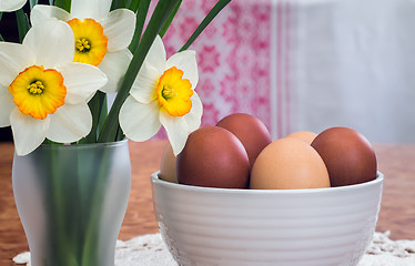 Image showing Easter eggs in a ceramic vase and flowers daffodils.