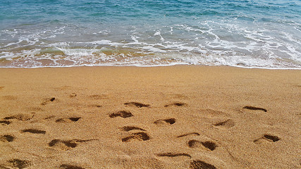 Image showing Waves and footprints on the sand beach