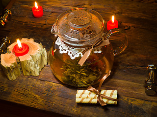 Image showing exotic green tea with flowers in glass teapot 