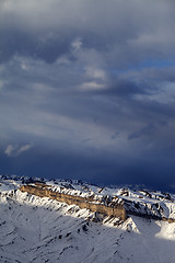 Image showing Sunlight winter mountains and storm clouds at evening.