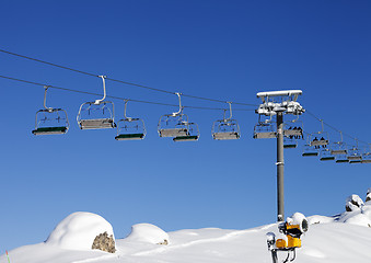 Image showing Chair-lift at ski resort at sun day after snowfall