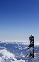 Image showing Snowboard in snow on off-piste slope at sun day