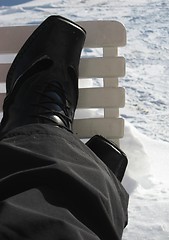 Image showing Resting the legs on a chair in the snow