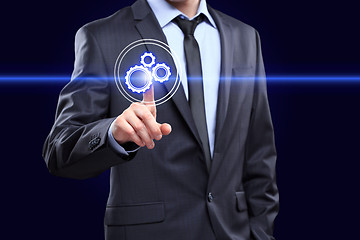 Image showing business, technology and internet concept - businessman pressing button with mechanism icon on virtual screens