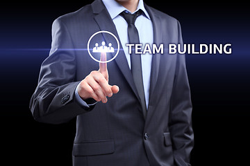 Image showing Businessman pressing button on touch screen interface and select Team building. Business, technology concept.