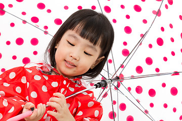 Image showing Chinese Little Girl Holding umbrella with raincoat