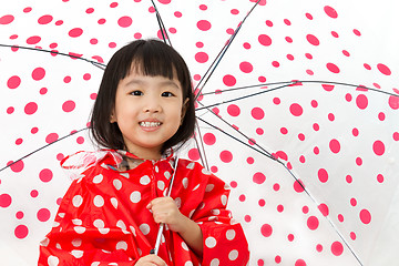 Image showing Chinese Little Girl Holding umbrella with raincoat