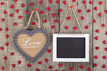 Image showing Empty wooden blackboard sign and heart shape frame