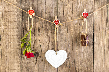 Image showing Red rose with white shape heart and chocolate on wooden