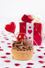 Image showing cup-cake with cherry in front of gift box 