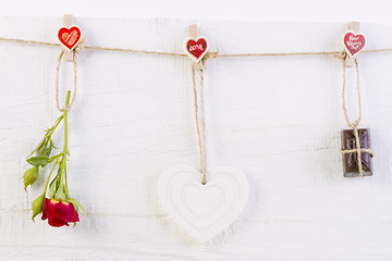 Image showing Red rose with white shape heart and chocolate on white